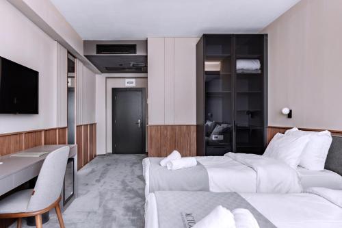 a hotel room with a bed and a desk at Actor Hotel in Skopje