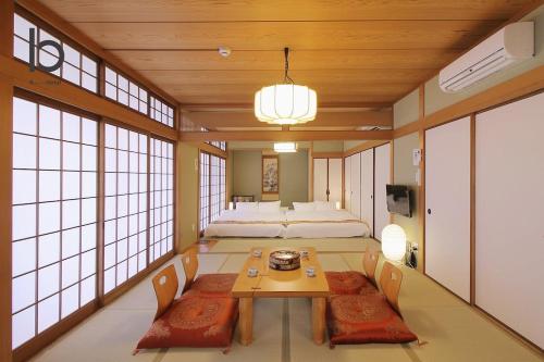 a room with a bed and a table and chairs at Hanagin by b hotel - 3 Bedroom Japanese apartment for 11 people 201 in Hiroshima