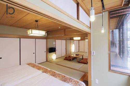 a bedroom with a bed and a living room at Hanagin by b hotel - 3 Bedroom Japanese apartment for 11 people 201 in Hiroshima