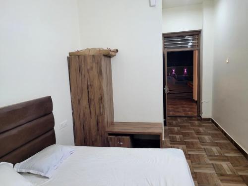 a bedroom with a bed and a wooden door at Marks Farm in Alwar