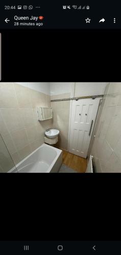 a bathroom with a white tub and a toilet at Queenel Room in Eltham