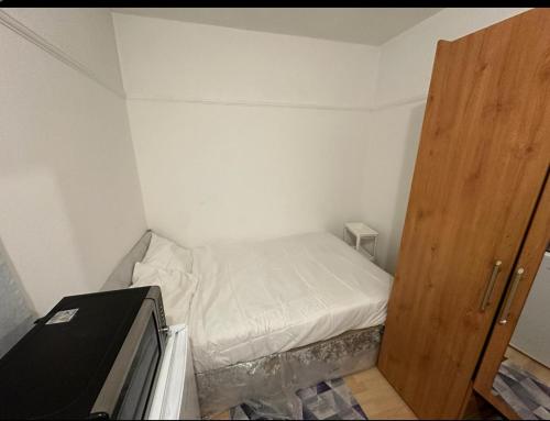 una piccola camera con letto e porta in legno di Queenel Room a Eltham