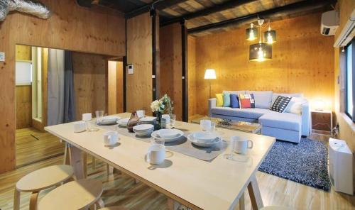 a living room with a table and a couch at Nishikaniya by b hotel - Large Apartment 10mins walk from Hiroshima Station in Hiroshima