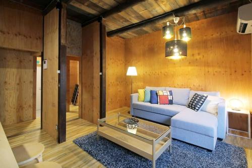 a living room with a couch and a table at Nishikaniya by b hotel - Large Apartment 10mins walk from Hiroshima Station in Hiroshima