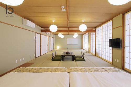 a large room with a table and chairs in it at Hanagin by b hotel - Large 2 bedroom apartment for 12people 301 in Hiroshima