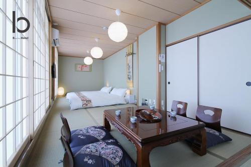 a room with a bed and a table and chairs at Hanagin by b hotel - Spacious 2 bedroom Japanese Apt for 10 ppl 401 in Hiroshima