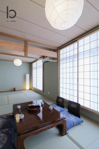 a room with a table and some windows at Hanagin by b hotel - Spacious 2 bedroom Japanese Apt for 10 ppl 401 in Hiroshima