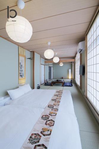 a large room with a large bed and two lights at Hanagin by b hotel - Spacious 2 bedroom Japanese Apt for 10 ppl 401 in Hiroshima