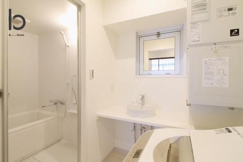 uma casa de banho branca com um lavatório e um chuveiro em Hanagin - Spacious 2 bedroom Japanese Apt for 10 ppl 401 em Hiroshima