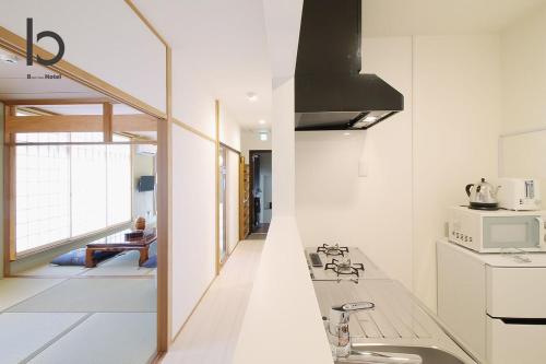 a kitchen with a stove and a microwave at Hanagin - Spacious 2 bedroom Japanese Apt for 10 ppl 401 in Hiroshima