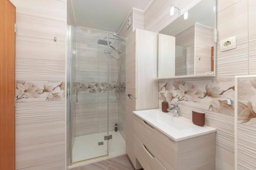 een witte badkamer met een douche en een wastafel bij Cadys Apartment in Kranjska Gora