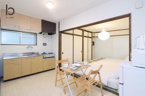 a kitchen with a bed and a table and chairs at Dai3Himawari - Stylish Apt 3mins walk PeacePark 4ppl in Hiroshima