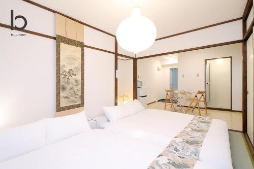 een slaapkamer met 2 bedden en een eetkamer bij Dai3Himawari - Stylish Apt 3mins walk PeacePark 4ppl in Hiroshima