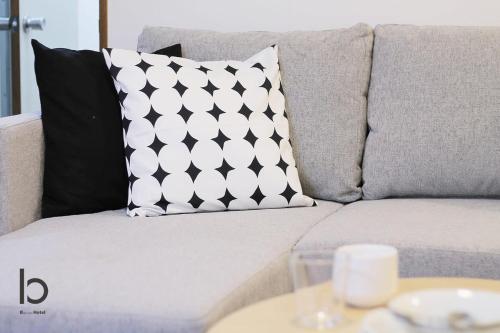 a couch with a pillow on it with a table at bHOTEL Dai3Himawari - Japanese Apt 3mins walk PeacePark 6ppl in Hiroshima