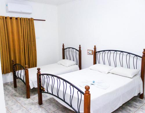 two twin beds in a room with at Delta Hotel in Andradina