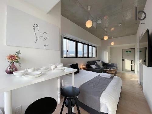 広島市にあるbHOTEL Nekoyard - New Modern Beautiful 1 BR Apartment, Very Near Peace Park, for 6Pplのベッド1台とリビングルームが備わる客室です。