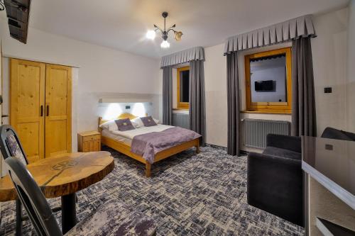 a hotel room with a bed and a table at Śwarna Wynajem Pokoi in Zakopane