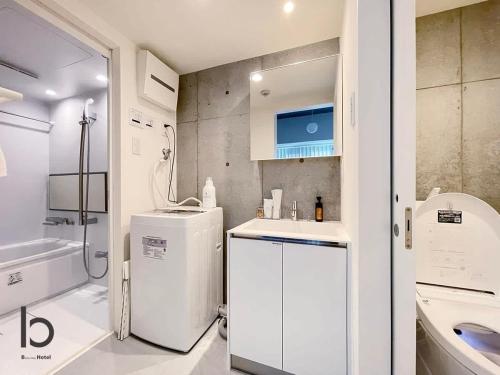 a white bathroom with a sink and a refrigerator at bHOTEL Nekoyard - NEW 1 BR Apartment, Near Peace Park, Good 6Ppl in Hiroshima
