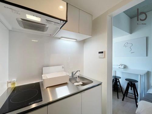 cocina con fregadero y encimera en bHOTEL Nekoyard - NEW 1 BR Apartment, Near Peace Park, 6Ppl en Hiroshima