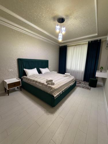 a bedroom with a large bed with a green headboard at City Plaza Krenkel 2 in Samarkand