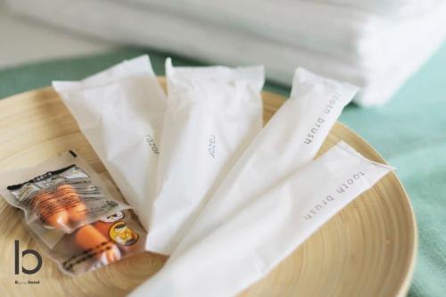 a wooden plate with two white napkins on a table at bHOTEL Nekoyard - 1 BR Apartment, Near Peace Park, 6Ppl in Hiroshima