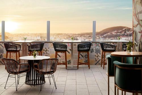 a patio with tables and chairs and a view of a city at NH Tenerife in Santa Cruz de Tenerife