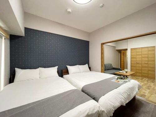 2 Betten nebeneinander in einem Zimmer in der Unterkunft bHOTEL Casaen - 1BR Apartment with beautiful City View Near Shopping District For 6Ppl in Hiroshima