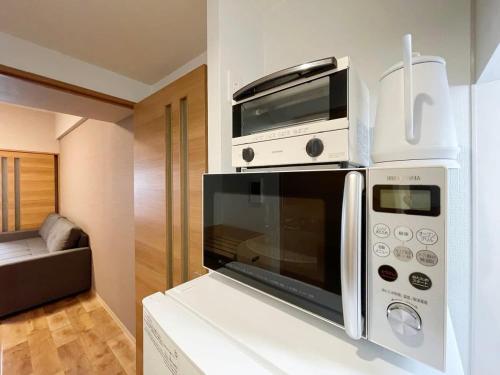 a microwave on top of a counter in a kitchen at bHOTEL Casaen - 1BR Apartment with beautiful City View Near Shopping District For 6Ppl in Hiroshima