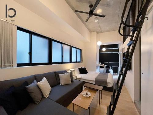 a living room with a couch and a loft at b hotel Nekoyard - Loft Studio 5 Min Walk to Peace Park in Hiroshima