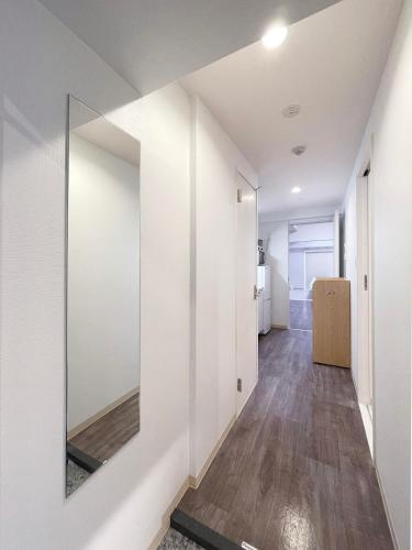 a hallway with white walls and a mirror at Casaen by b hotel - 1BR apartment close to Hondori Shopping Arcade in Hiroshima