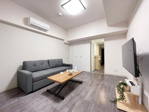 a living room with a couch and a table at Casaen by b hotel - 1BR apartment close to Hondori Shopping Arcade in Hiroshima