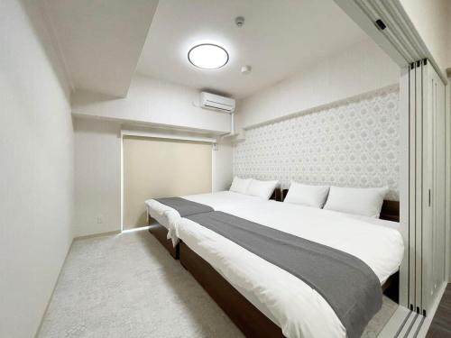 um quarto com uma cama grande num quarto em bHOTEL Casaen - Spacious 1BR Apt For 6 Ppl Great Location with room wifi em Hiroshima