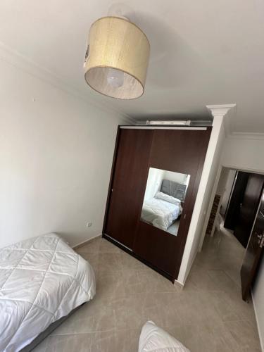 a bedroom with a bed and a large mirror at Appart Firdaous in Martil