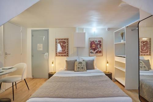 une chambre avec un lit, une table et une chaise dans l'établissement Studio Place Vendome by Studio prestige, à Paris