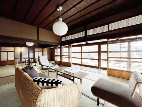 a living room with couches and tables and windows at b local Hayase House - Vacation Villa facing ocean view with BBQ Grill Free Parking Space in Kure