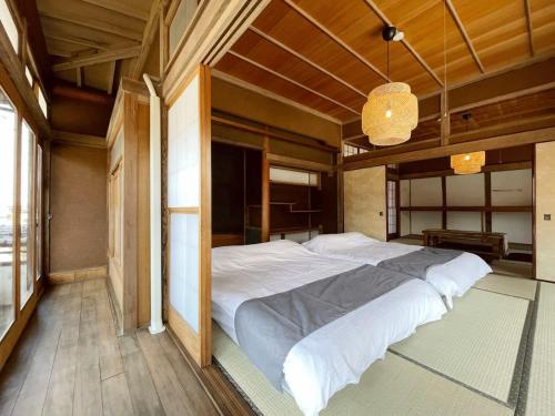 1 dormitorio con 1 cama blanca grande. en bLOCAL Hayase House - Vacation Villa facing ocean view with BBQ Grill Free Parking Space en Kure