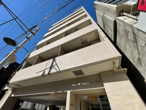 un edificio con un cartel delante en Casaen by b hotel- Modern 1 BR near Hondori District for 6 Ppl, en Hiroshima