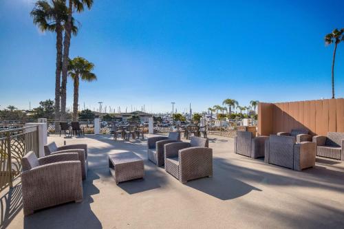 a patio with chairs and tables and palm trees at Comfort Inn San Diego Airport At The Harbor in San Diego