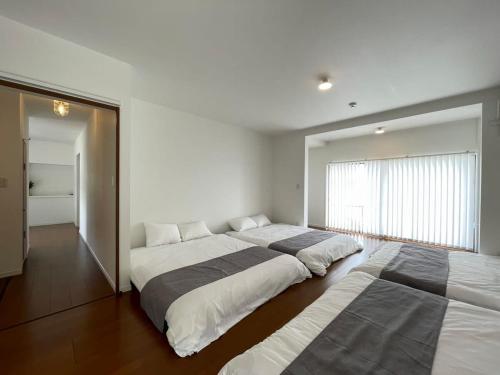 Rúm í herbergi á bLOCAL Sugawa House - 1 Bedroom House with Beautiful Ocean View for 12 Ppl