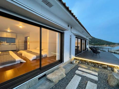 a house with a balcony with two beds and a bedroom at bLOCAL Sugawa House - Exclusive Seaside Escape in Ocean House in Kure