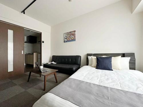 廣島的住宿－bHOTEL Nagomi - Well-Furnished with balcony Apt for 3 Ppl，酒店客房,配有床和沙发