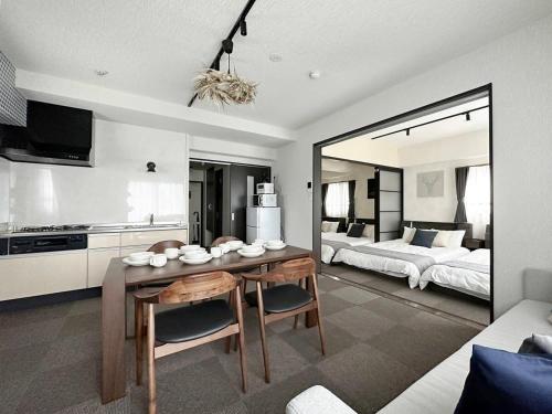 uma sala de estar com uma mesa e um quarto em bHOTEL Nagomi - Beautiful 2BR Apt City Center for 10 Ppl em Hiroshima