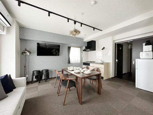 uma sala de estar com uma mesa e uma cozinha em bHOTEL Nagomi - Beautiful 2BR Apt City Center for 10 Ppl em Hiroshima