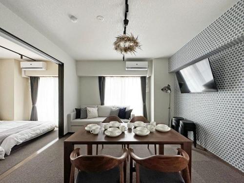 a room with a table and chairs and a bed at bHOTEL Nagomi - Beautiful 2BR Apt City Center for 10 Ppl in Hiroshima