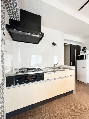 a kitchen with a stove and a sink at bHOTEL Nagomi - Beautiful 2BR Apt City Center for 10 Ppl in Hiroshima
