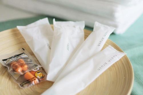 a wooden plate with two white napkins on a table at bHOTEL Nagomi - Beautiful 2BR Apt City Center for 10 Ppl in Hiroshima