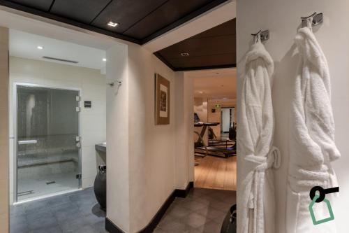 La salle de bains est pourvue de serviettes blanches accrochées au mur. dans l'établissement Hotiday Collection Paris - Arc de Triomphe, à Paris