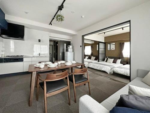 a living room with a dining room table and a bedroom at bHOTEL Nagomi - Large 2BR Apt City Center for 10 Ppl in Ōsukachō