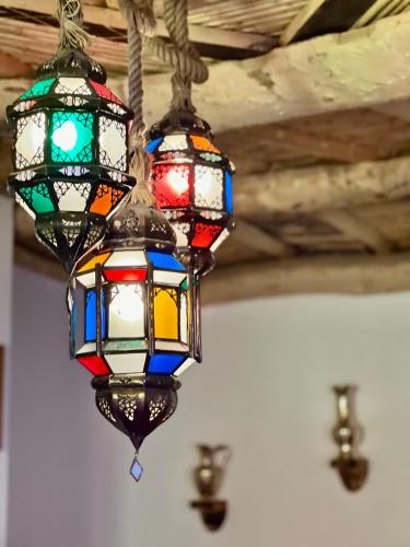 three colorful stained glass lights hanging from a ceiling at Grand Canyon Lodge Dades in Aït Idaïr