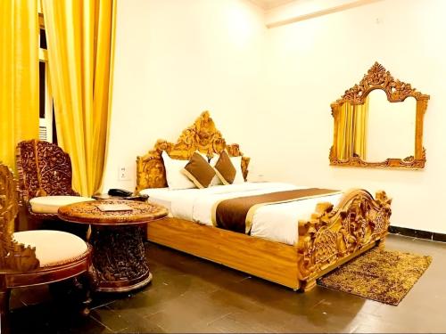 1 dormitorio con cama, espejo y mesa en The NDVL Hotel - Top Rated and Most Awarded Property in Haridwar en Haridwār